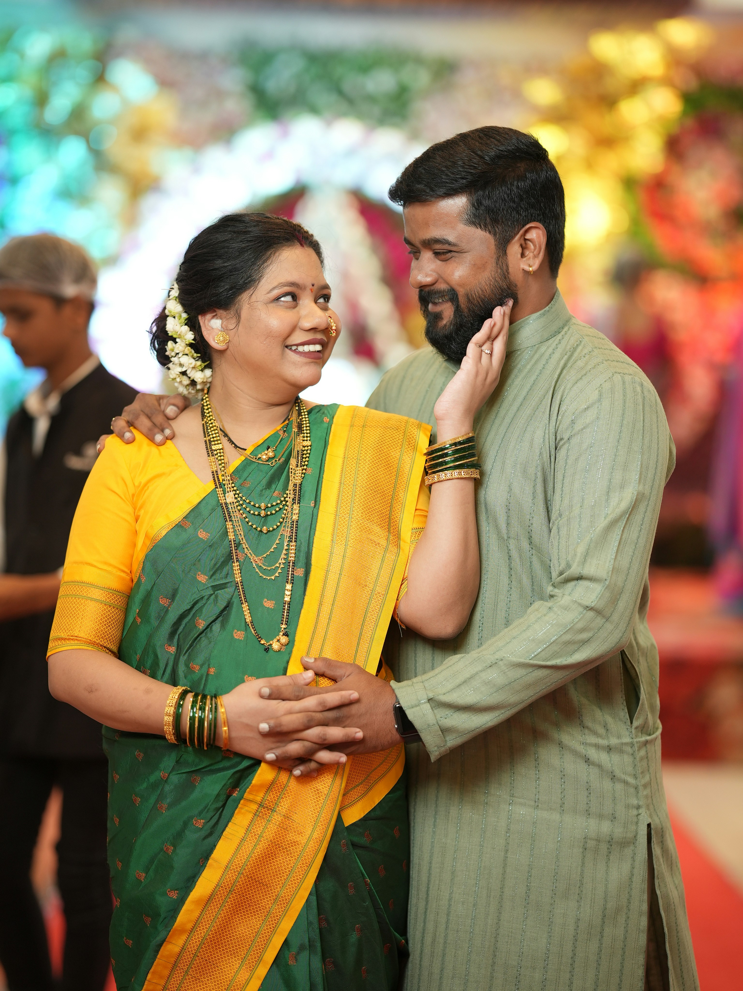 Couple in vibrant traditional attire sharing an intimate moment at their celebration