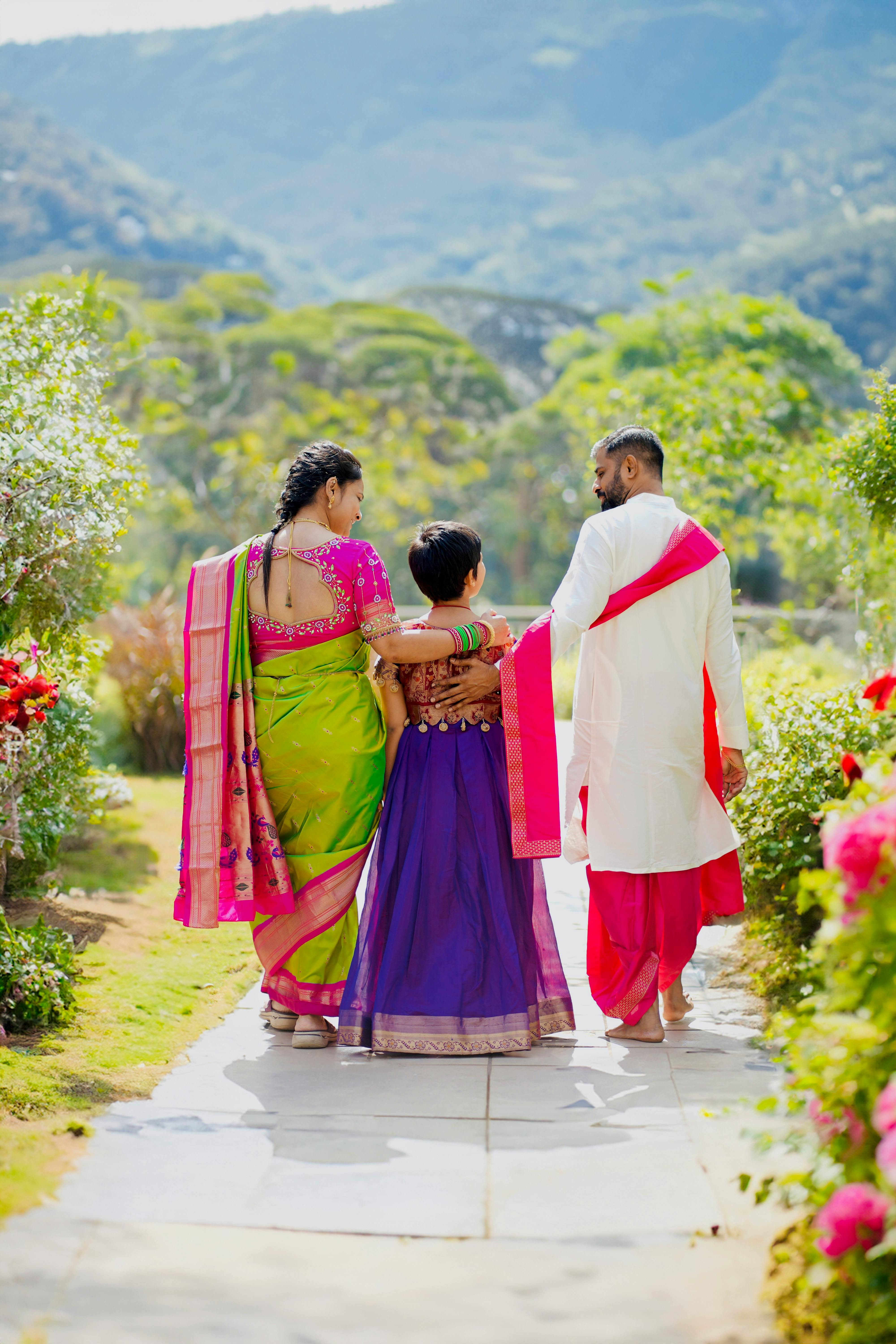 Family of three walking along a floral garden pathway