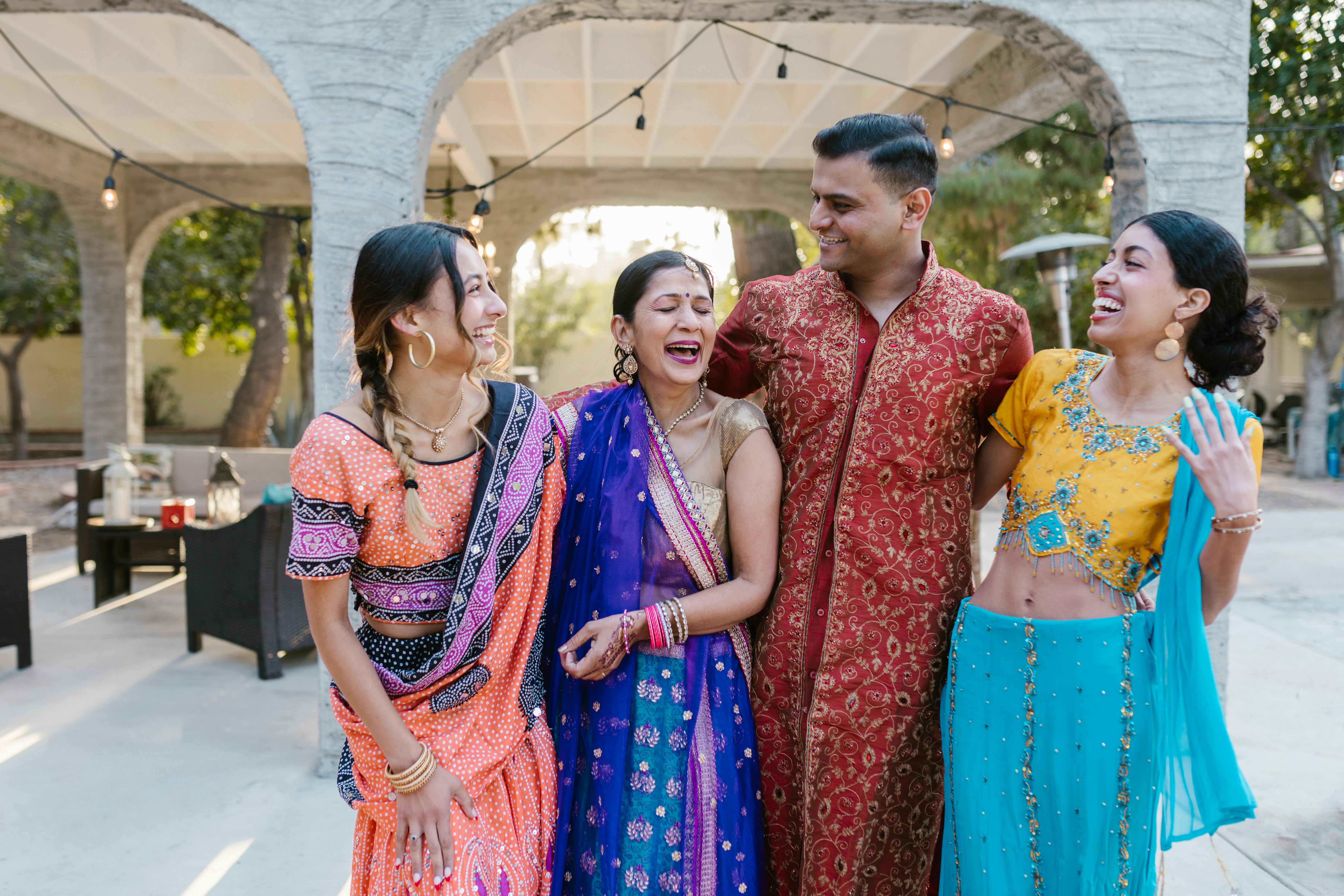 Group of friends laughing together at an outdoor celebration under festoon lights