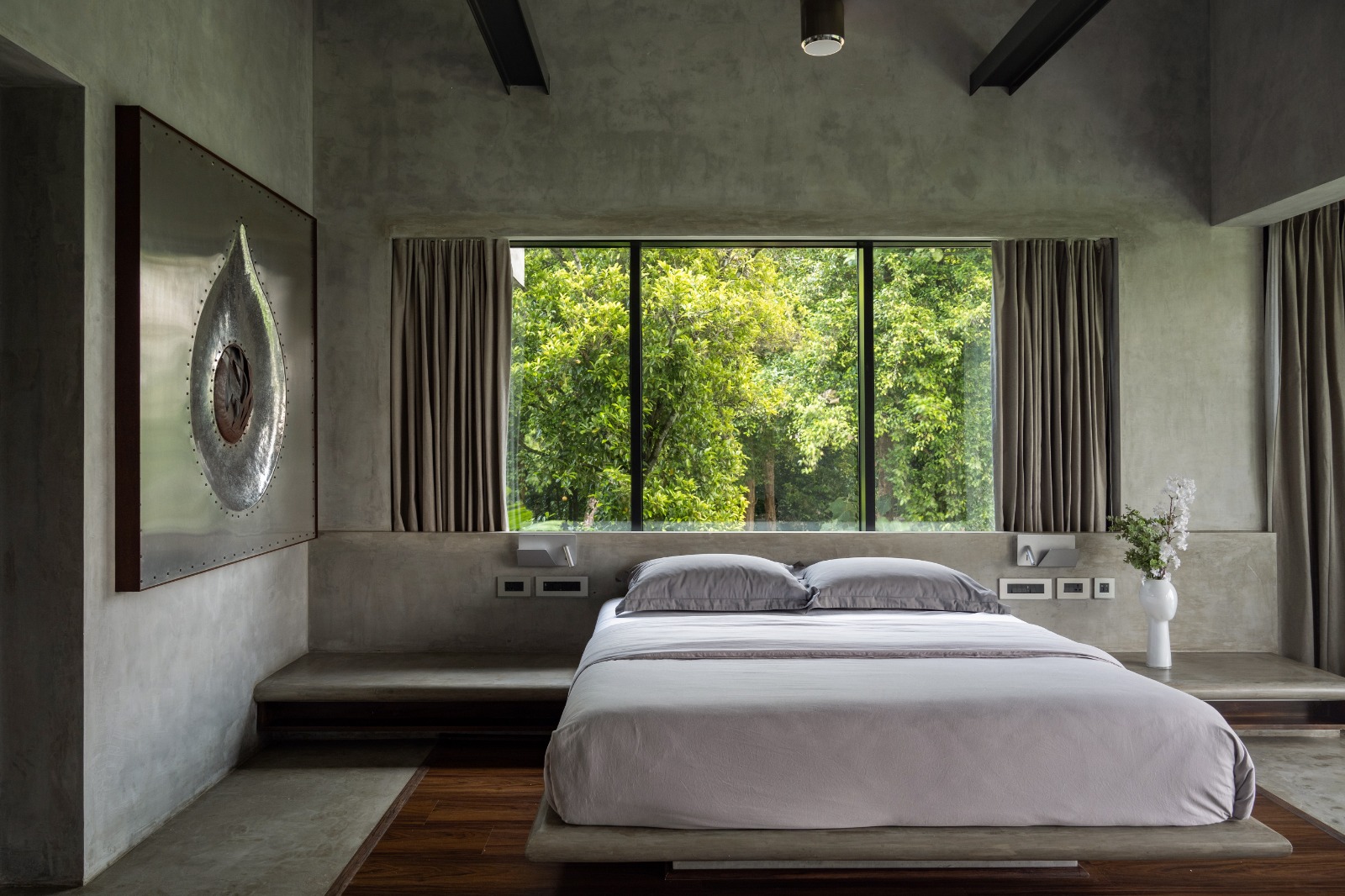 Sovnear master bedroom with floor-to-ceiling windows framing the forest