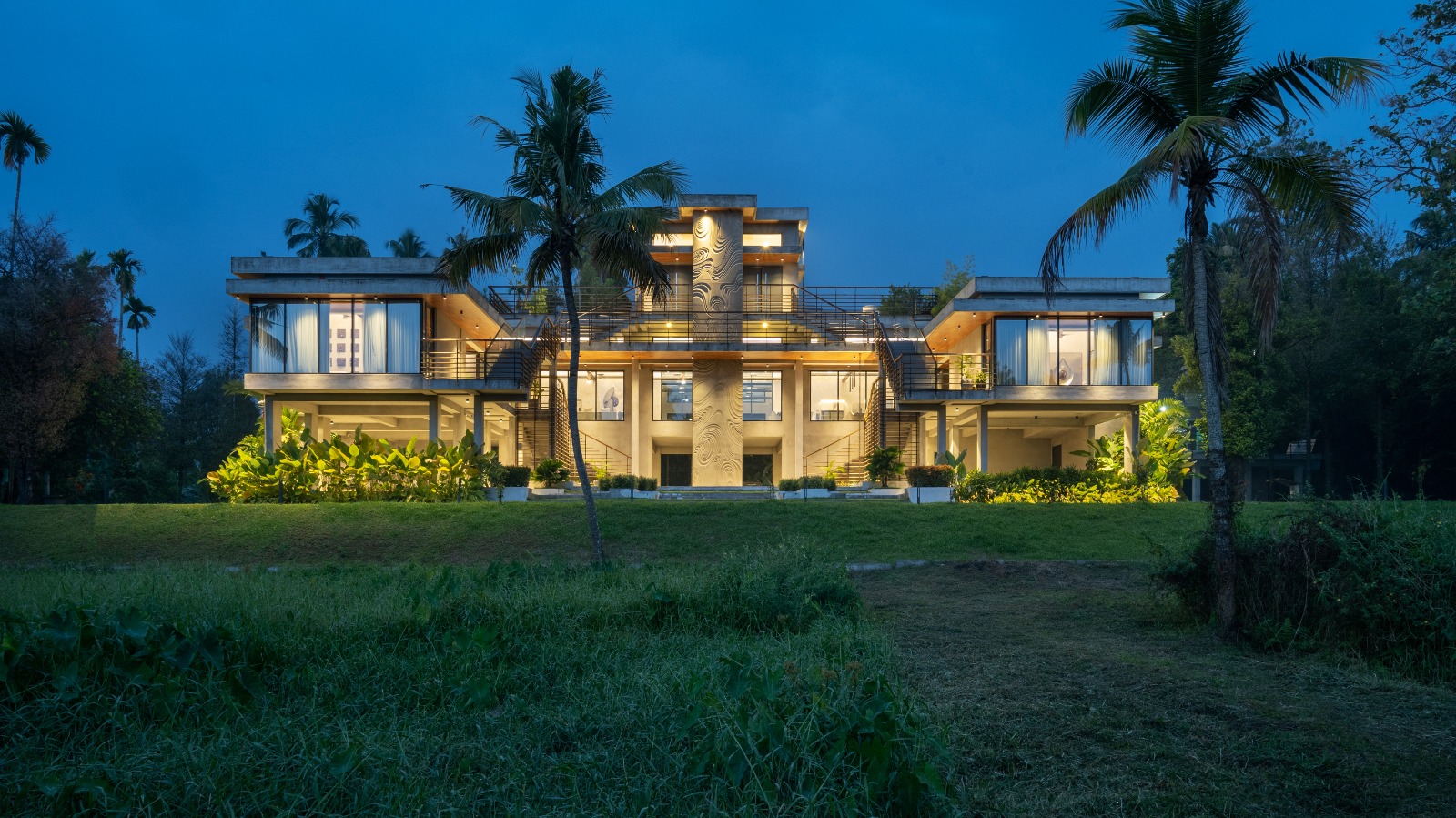 Sovnear estate illuminated at night — blue hour with palm trees