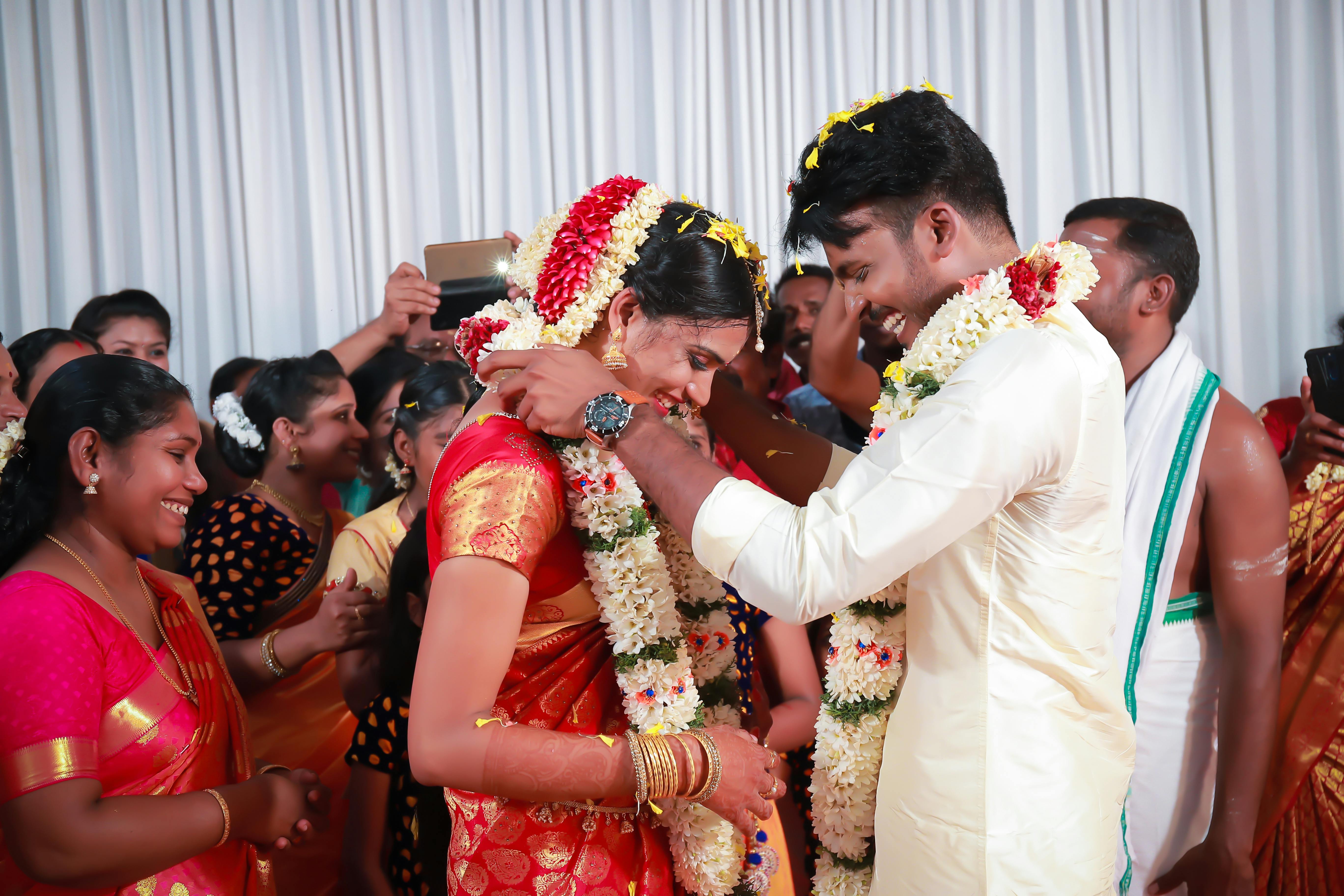 Traditional garland exchange ceremony moment surrounded by family