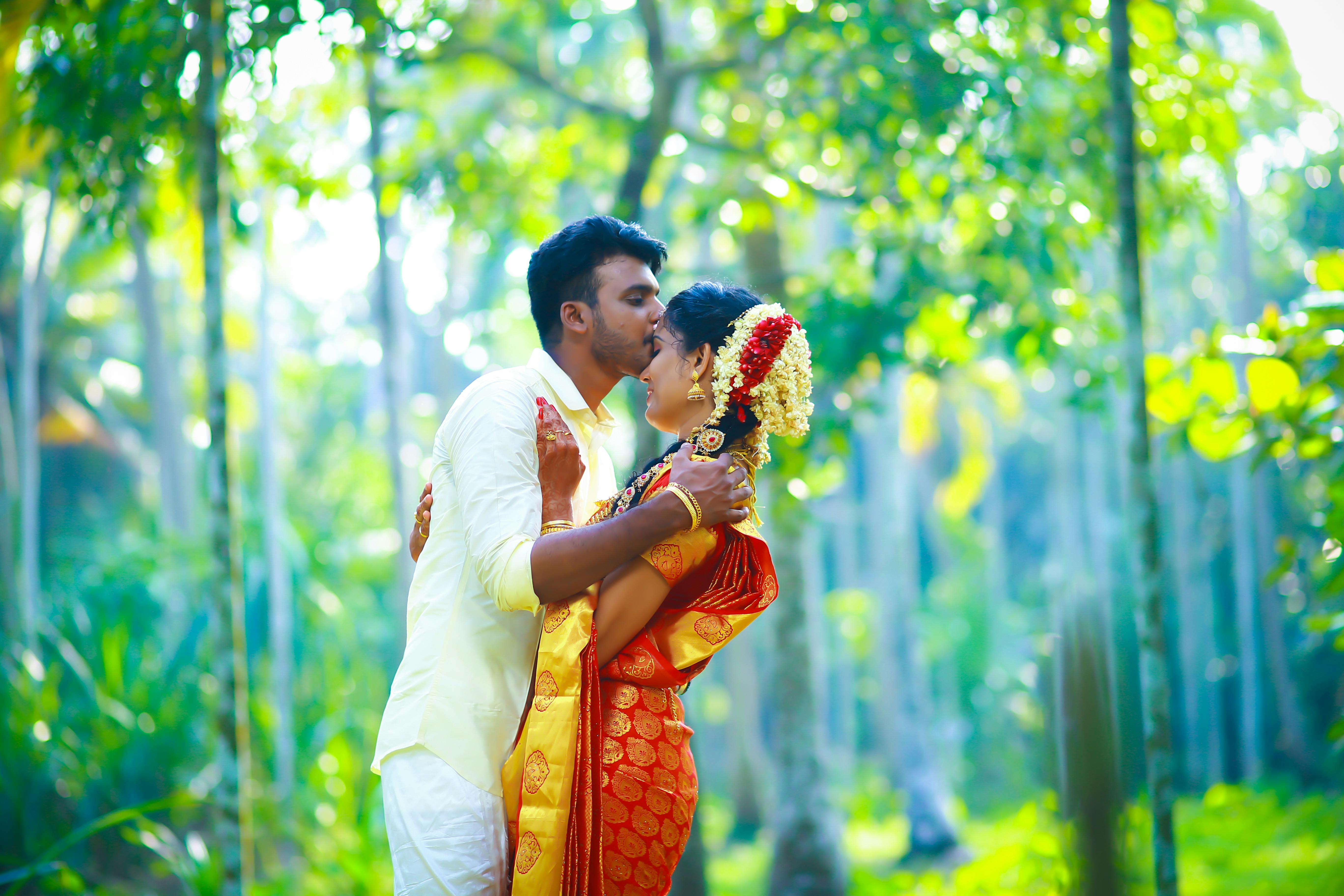 Kerala wedding couple embracing amid a lush tropical forest