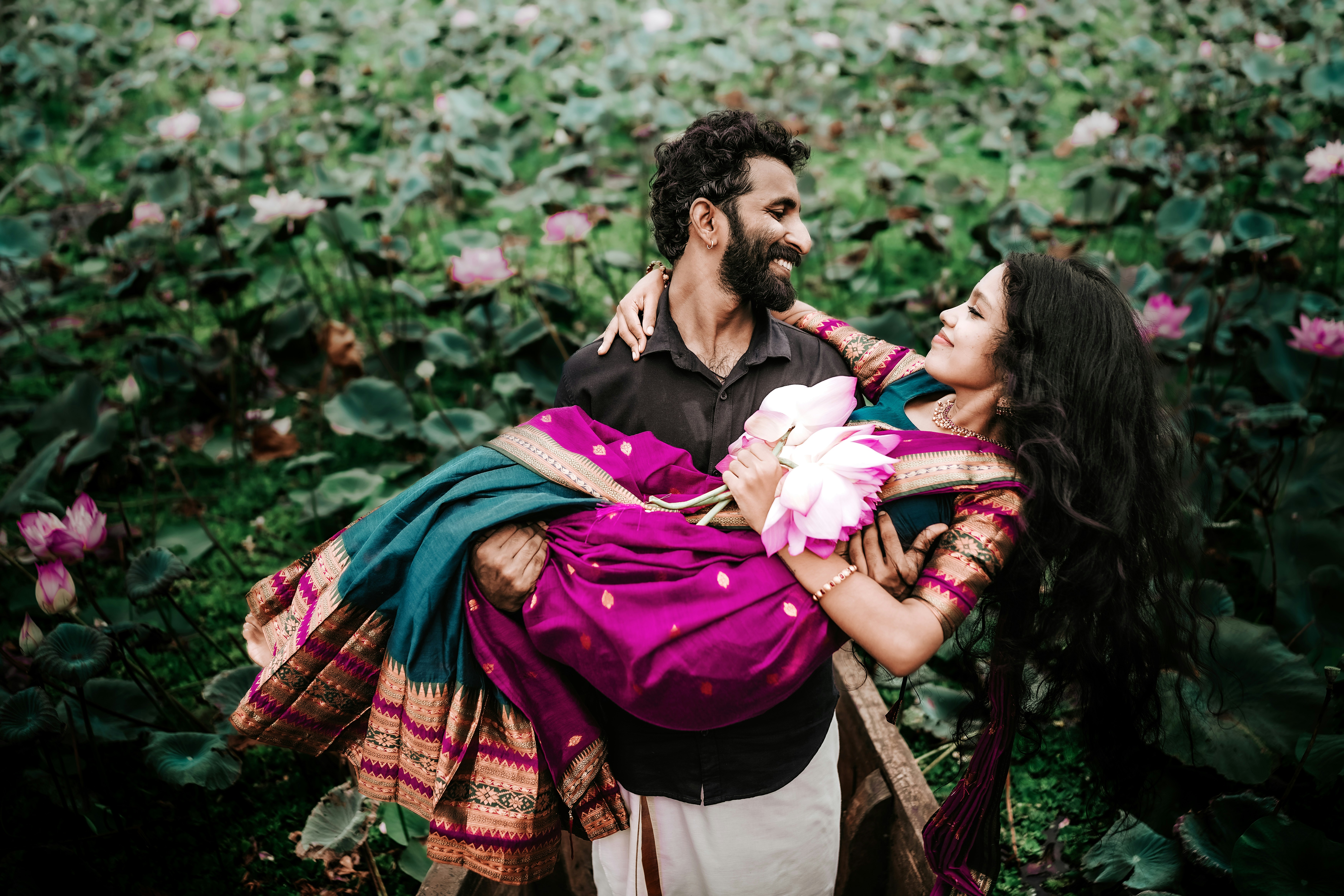 Couple laughing together surrounded by a blooming lotus garden