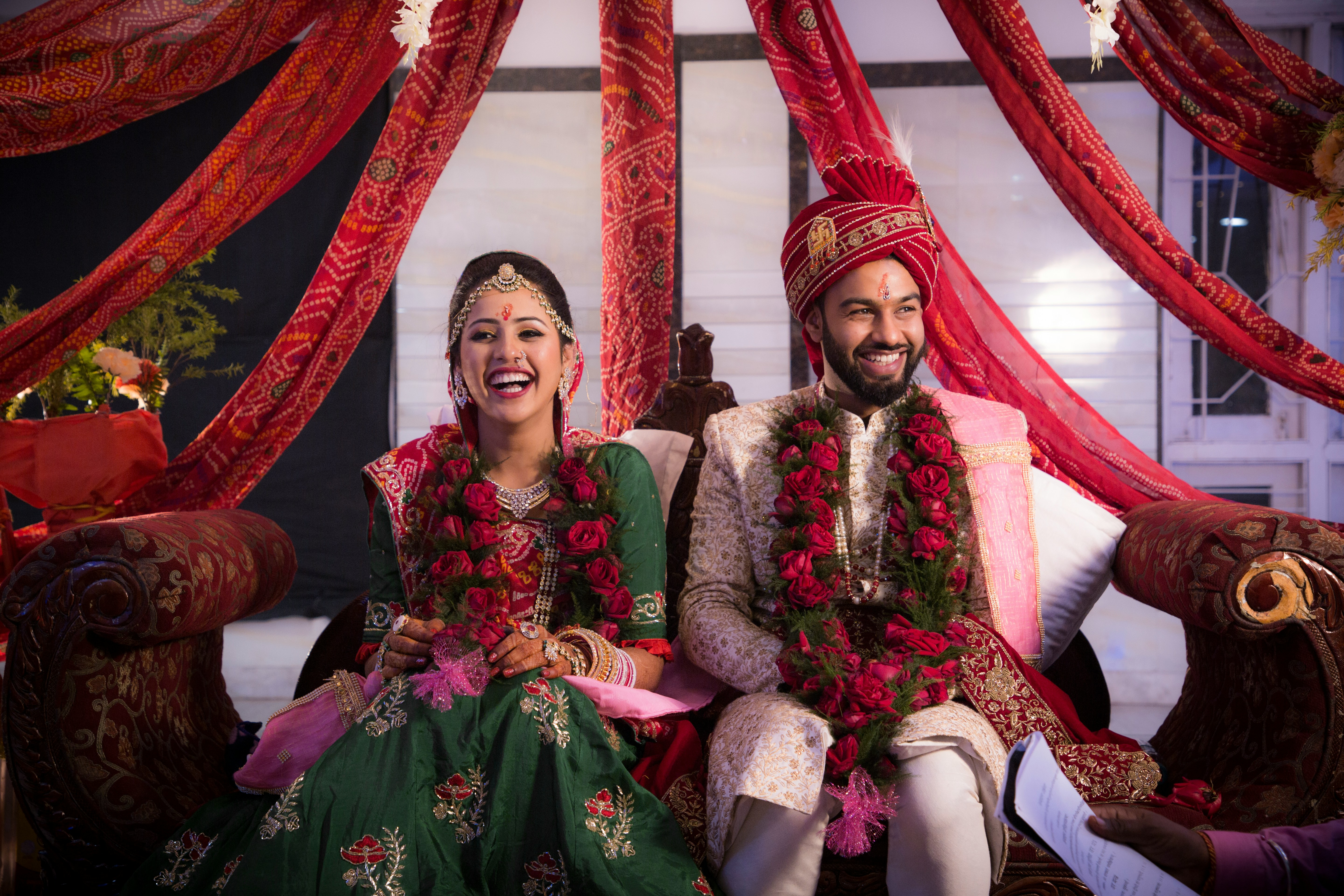 Couple laughing joyfully together at the wedding mandap